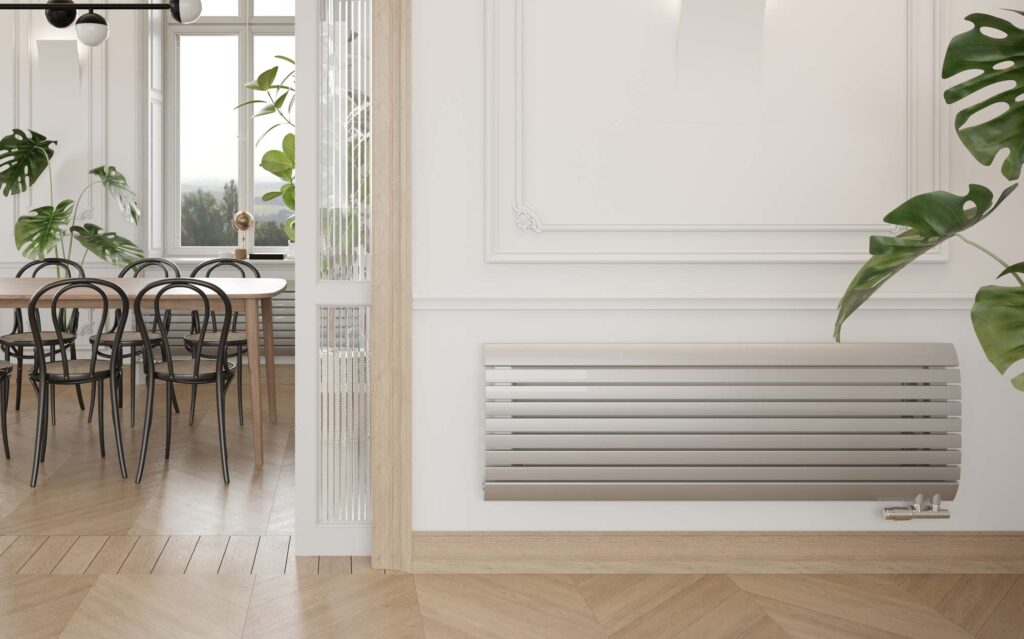 Grzejnik ENIX Madera w kolorze białym 9010, zamontowany w klasycznym, przytulnym wnętrzu
