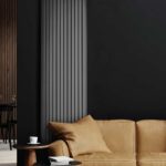 Grzejnik ENIX Memphis Plus w matowym, szarym kolorze, w minimalistycznym salonie z czarną ścianą i jasną, skórzaną kanapą